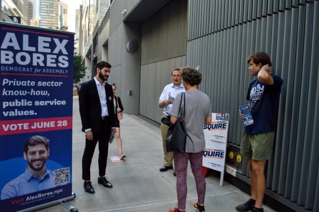 A prospective voter caught between NYS Assembly District 73 candidates Alex Bores (left), Russell Squire (center) and a representative of Adam Roberts (right). Photo: Abigail Gruskin