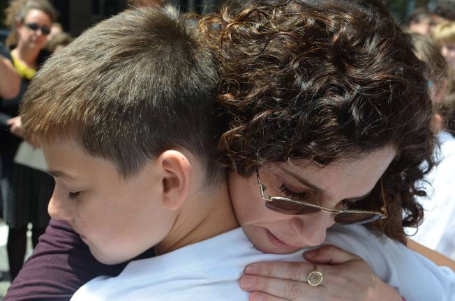 Dana Lerner embraces Jonathan Hume, who along with his twin brother Jacob, eulogized their former classmate Cooper Stock at a recent street renaming ceremony. Photo by Daniel Fitzsimmons.