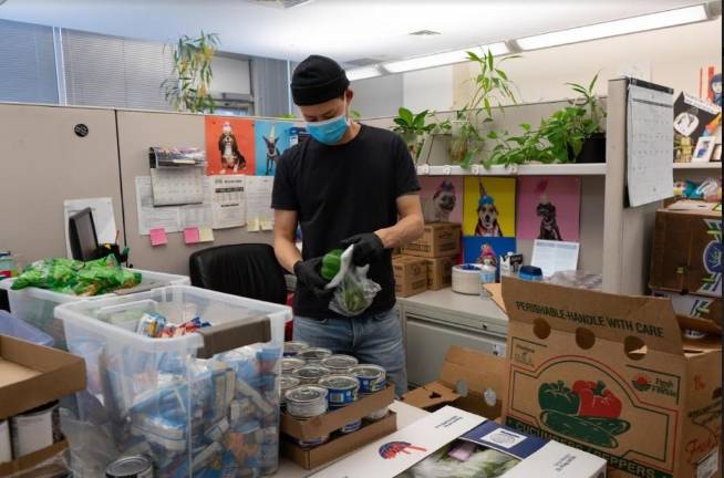 New York Cares volunteers prep meal delivery bags filled with dried and canned goods, which are delivered to those in need.