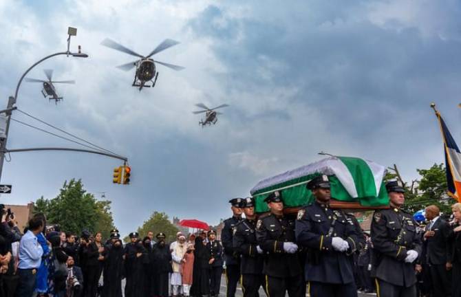 Police helicopters fly overhead as NYPD officers bear the coffin of their brother Didarul Islam following his funeral in the Parkchester section of the Bronx on July 31.