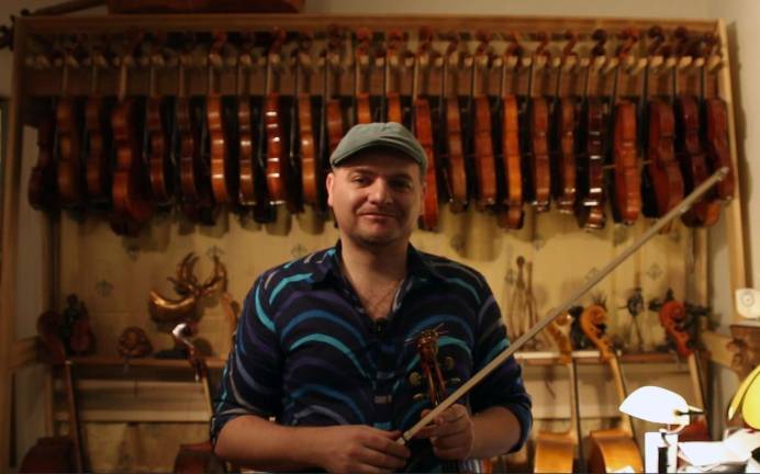 Lukas Wronski, a restorer, maker and dealer of violins, cellos, violas and bows, poses in his violin atelier.