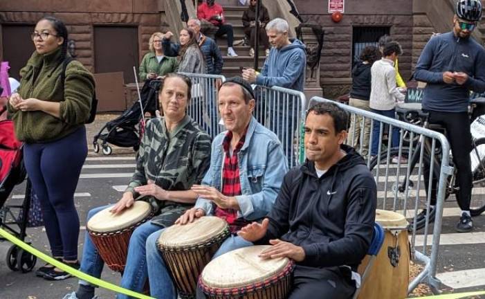 Bongo drummers bang out a tune as marathoners dash past on First Ave. Photo: Brian Berger