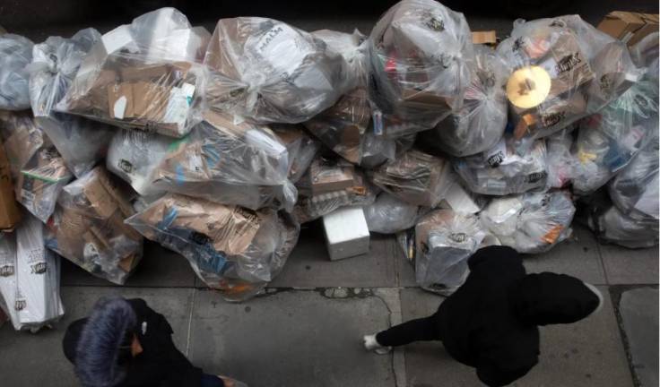 <b>Pedestrians walk by a giant pile of recycling in the Financial District, Nov. 29, 2022</b>. Photo: Ben Fractenberg/THE CITY