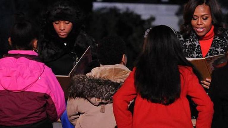 Michelle Obama (right) teams up with Mo’ne Davis to read “The Night Before Christmas” to youngsters. Photo: Wikimedia Commons.