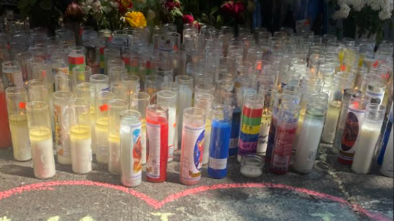 Candles and flowers on the sidewalk where Jason Negron and Michael Saint-Hilaire were killed on May 15.