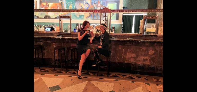 Karen Rempel and Art Deco Society VP Linda Zagaria clink glasses in Conwell Hall.
