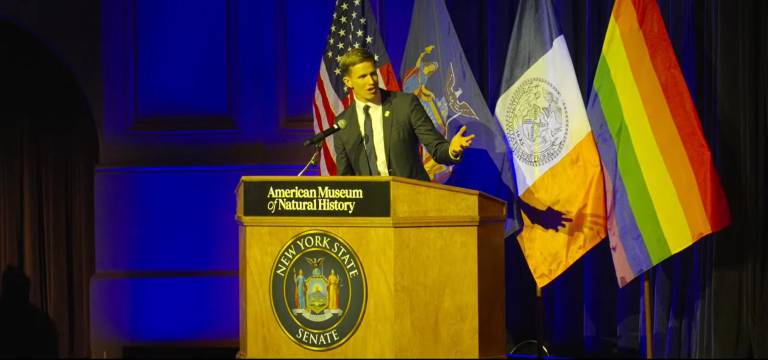 New York State Senator Erik Bottcher addressing the crowd after being sworn in at his inauguration ceremony at the American Museum of Natural History (AMNH).