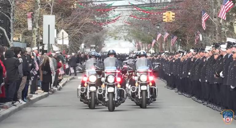 Police escort the flag drapped coffin bearting Patrick Brady mounted atop Ladder 120 at his funeral at St. Francis de Salles R.C. Church on Nov. 15, 2025.