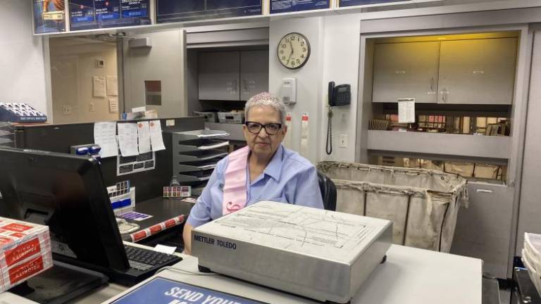Angie Serrano at her window where she helped the UWS neighborhood for the past 19 years in a postal career that spanned 39 years. <i>The Spirit </i>caught up with her on her last day on the job.