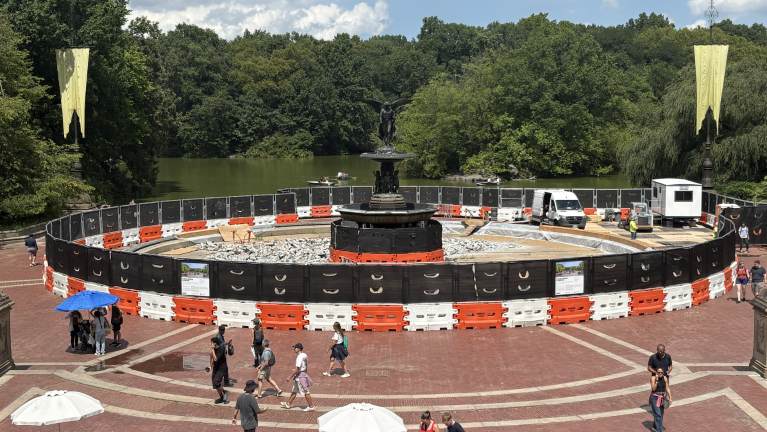 Bethesda Fountain from atop Bethesda Terrace, featuring the beginnings of construction and a handful of construction workers.