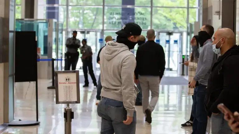 Federal agents wait in the lobby of 26 Federal Plaza to detain people after immigration hearings, May 28, 2025.